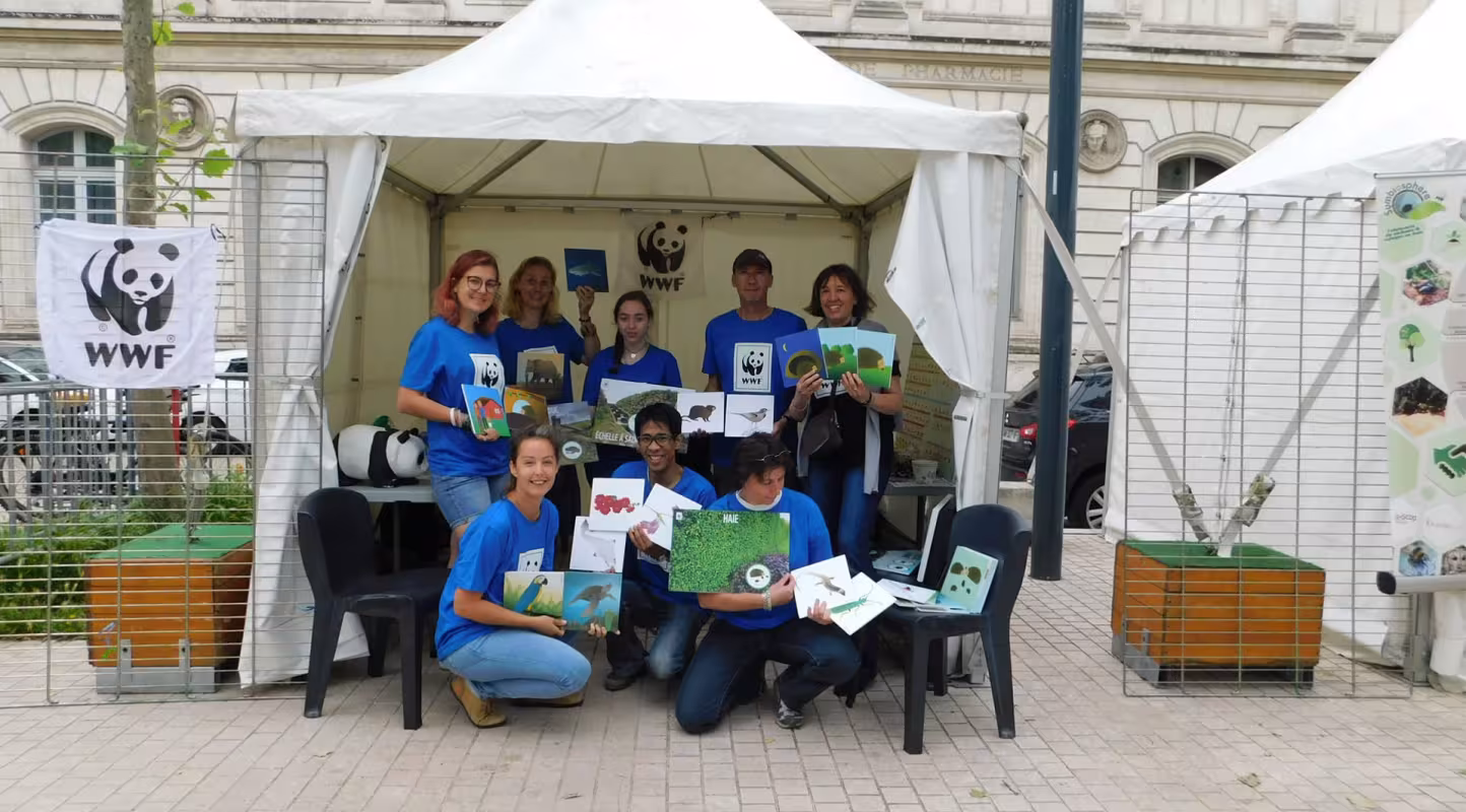 Des bénévoles sont devant un stand de sensibilisation. 